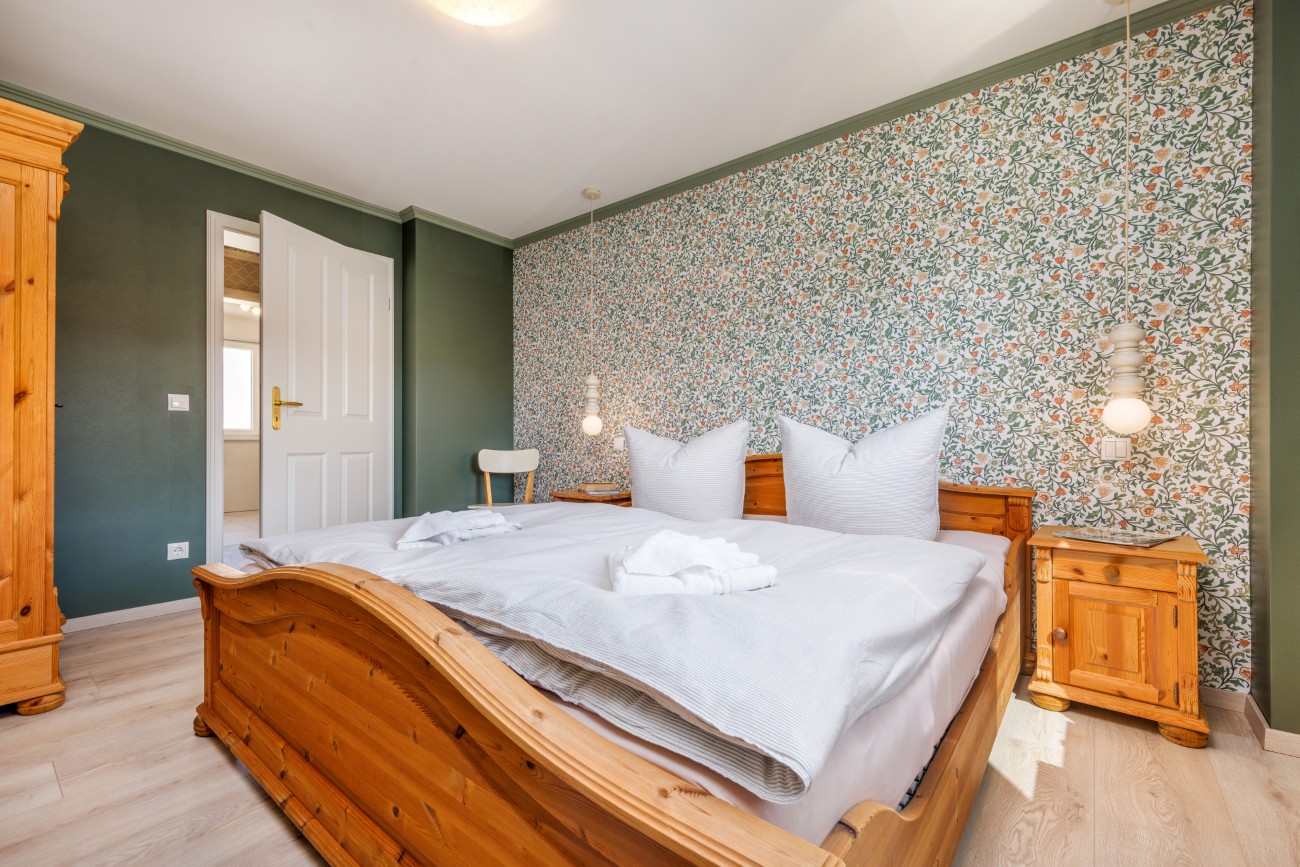 Fewo „Fräulein Helma am Meer“ Haus Meergold in Sassnitz auf Rügen - Ferienwohnung Fräulein Helma am Meer - Landhaustapete mit Blümchenmuster im Schlafzimmer