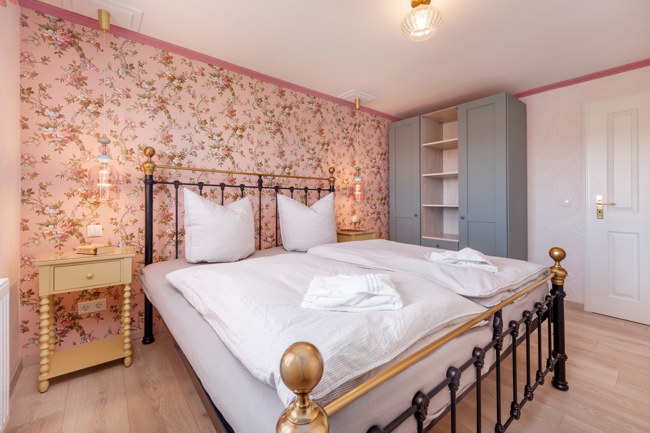 Fewo „Rosenwald am Meer“ Haus Meergold in Sassnitz auf der Insel Rügen - 2-Zimmer-Ferienwohnung Rosen am Meer - Schlafzimmer im Boutik-Stil mit Rosentapeten und Mesingbett