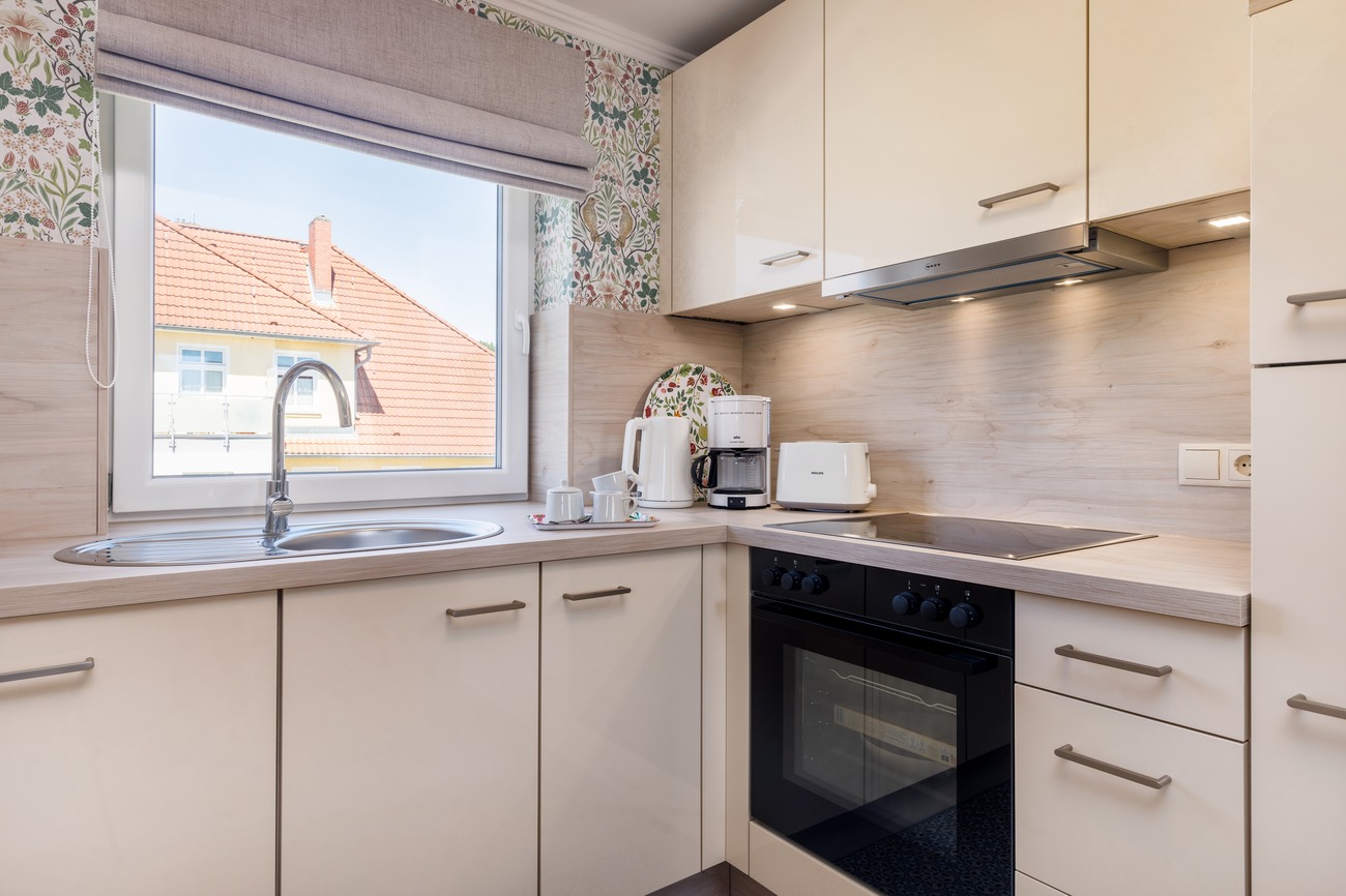 Fewo „Morgen am Meer“ Haus Meergold in Saßnitz auf Rügen - 2-Raum-Ferienwohnung Morgen am Meer - die moderne Küchenzeile mit Kaffeemaschine, Toaster, Wasserkocher, Backofen, Ceranfeld, Mikrowelle, Kühlgefrierkombination und Geschirrspüler